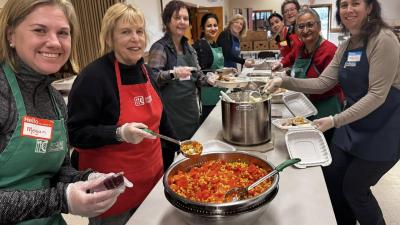 Assembly Line of smiling ABUW board and staff packing turkey dinners with tasty sides